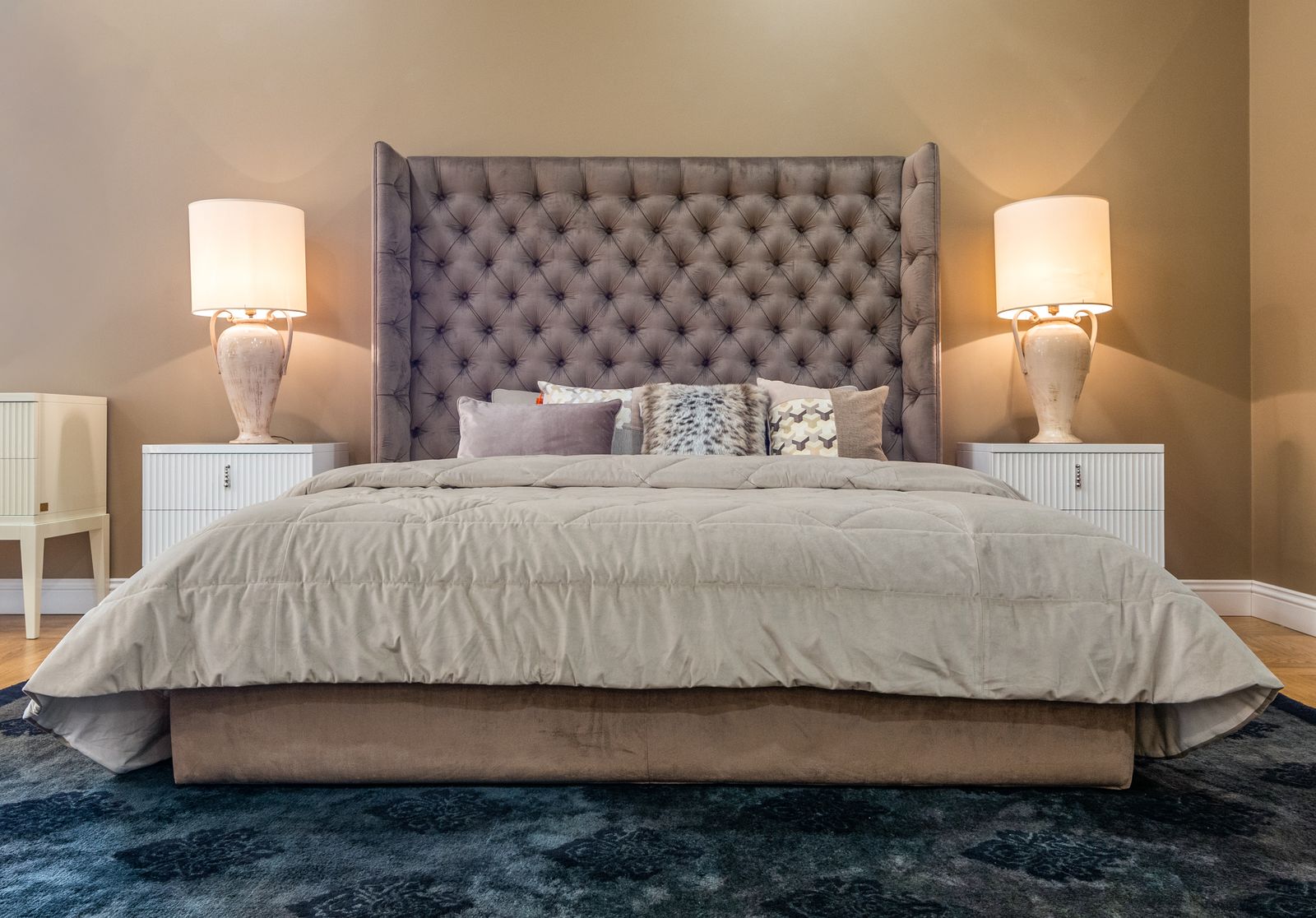 Master suite with upholstered bed and layered neutral textiles